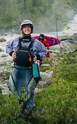 Profile Photo of Ava Christensen standing in whitewater kayaking gear in Voss, Norway.
