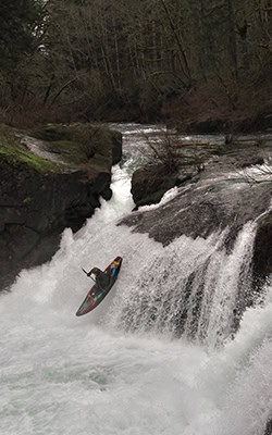 Chris Smith whitewater kayaking off of a waterfall.