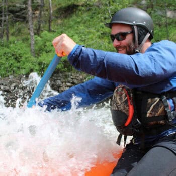Close up photo of Mike Locatelli raft guiding.