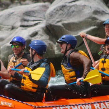 Wyatt Albright and clients laughing on a whitewater rafting trip.