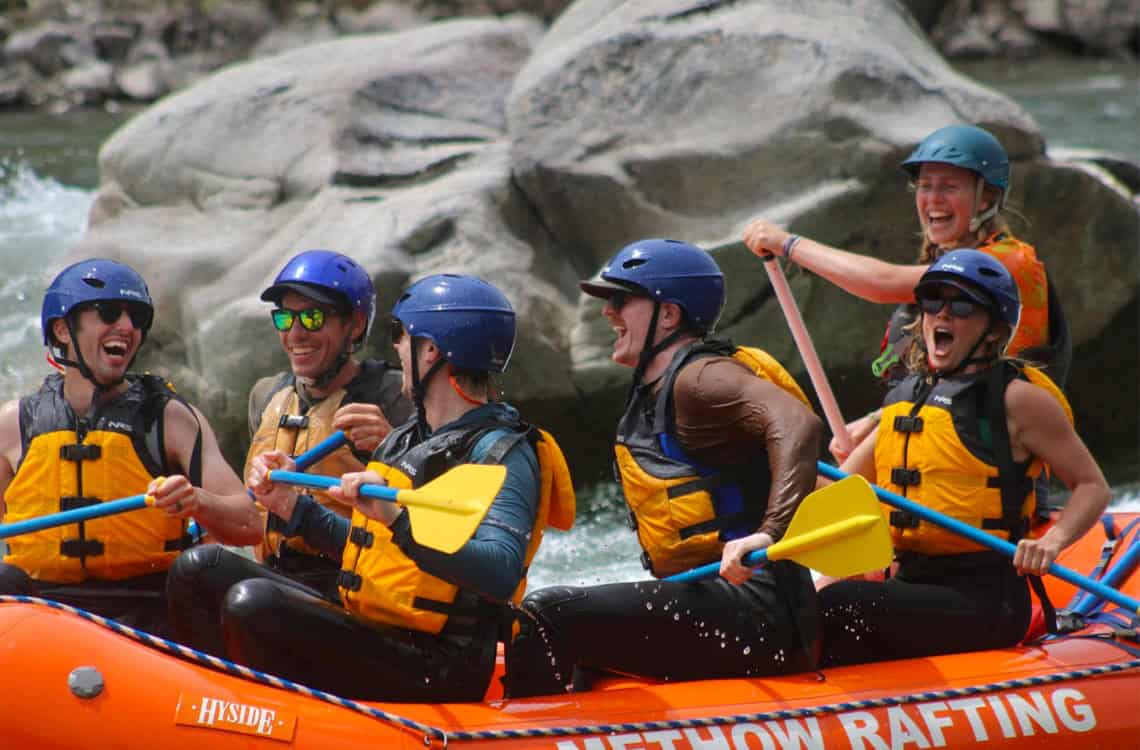 Wyatt Albright and clients laughing on a whitewater rafting trip.