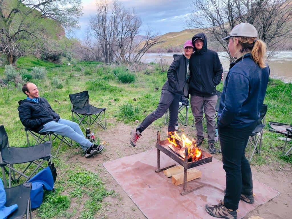 Enjoying a warm fire at the riverside camp