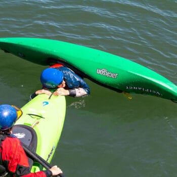 A student on an ACA kayak instructor course practices a t-rescue with a fellow kayaker.