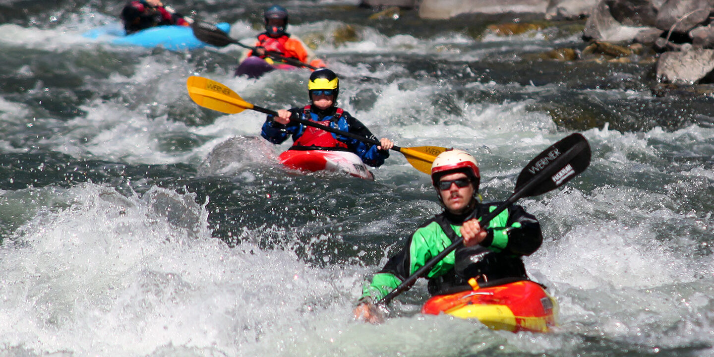 Kayakers in a line going through whitewater