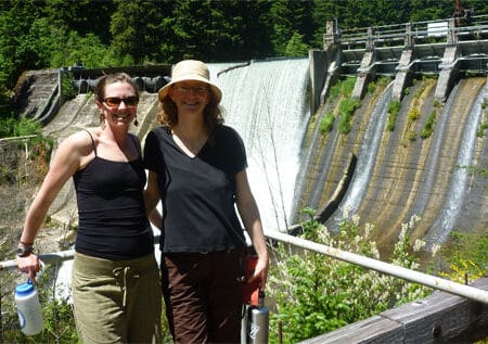 Two people standing in front of Condit dam