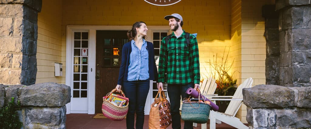 Couple pack a picnic lunch and yoga mat as pose on the porch of Lodge 902. Wet Planet Whitewater in Washington, Idaho, Oregon