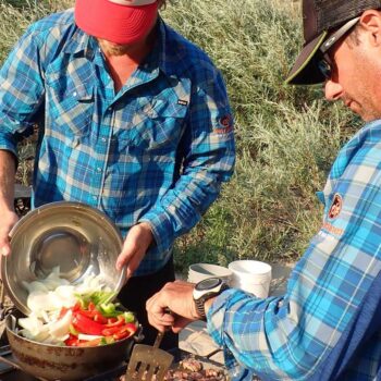 Two raft guides prepare vegetables for a dinner on the Main Salmon River rafting trip in Idaho.