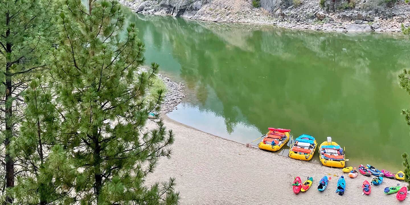 an aerial view of a variety of different raft boats and kayaks tethered to shore