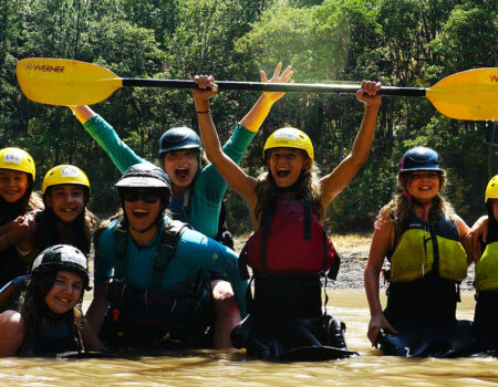 Kayak students smiling in the river