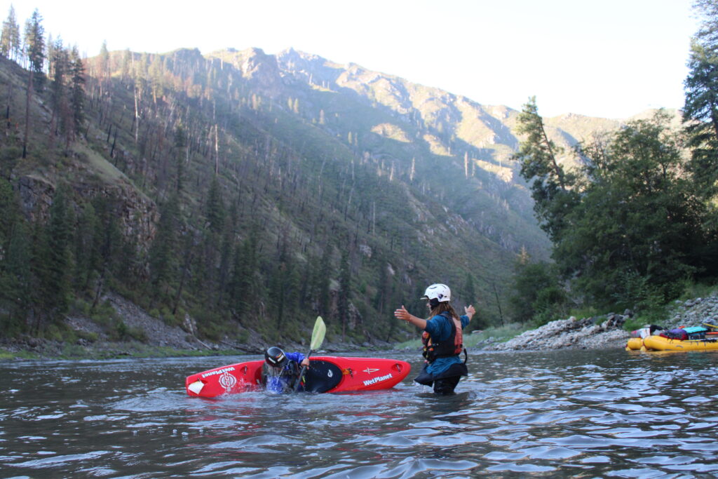 Wet Planet kayak instructor helping a guest with her roll on the Main Salmon River