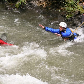 A student jumps from the bank of the river to practice rescuing an unconscious swimmer during a swiftwater river rescue course in Washington and Oregon.