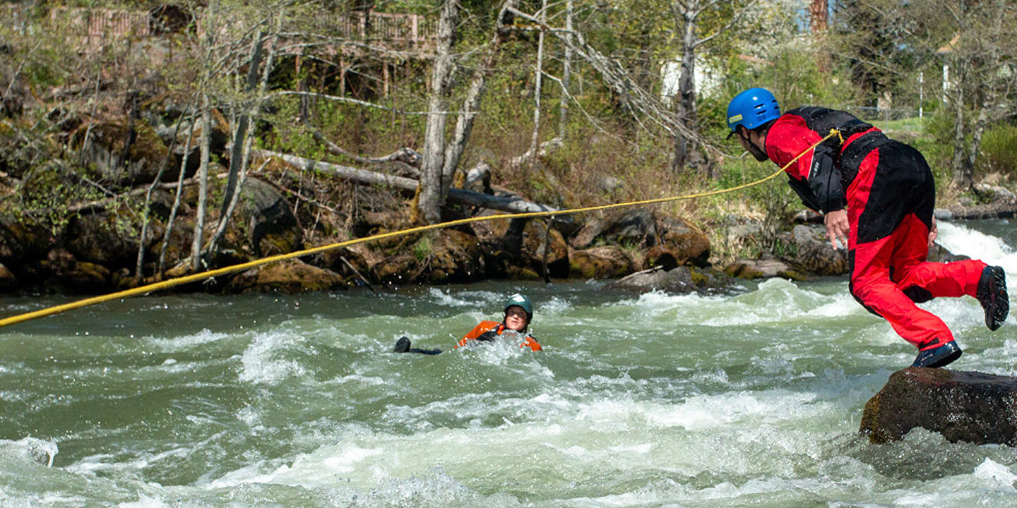 Person in River Rescue Course jumping into river after a swimmer