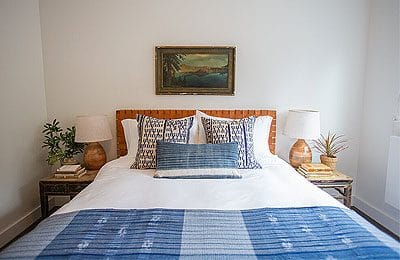 Neatly made bed with blue and white bedding at the RubyJune Inn. Wet Planet Whitewater in Washington, Idaho, Oregon
