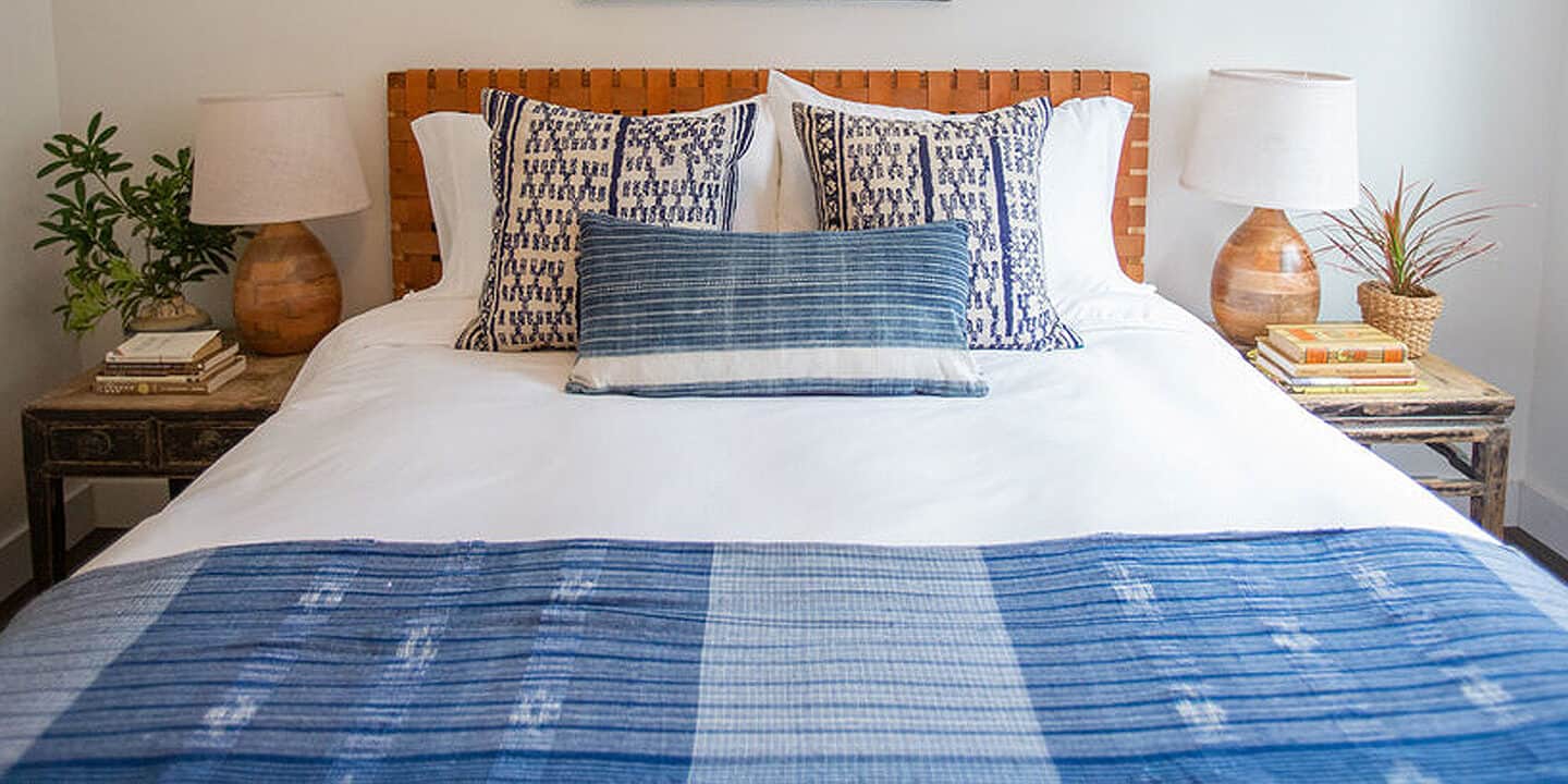 Bed neatly made with blue and white comforter at RubyJune Inn Columbia River. Wet Planet Whitewater in Washington, Idaho, Oregon