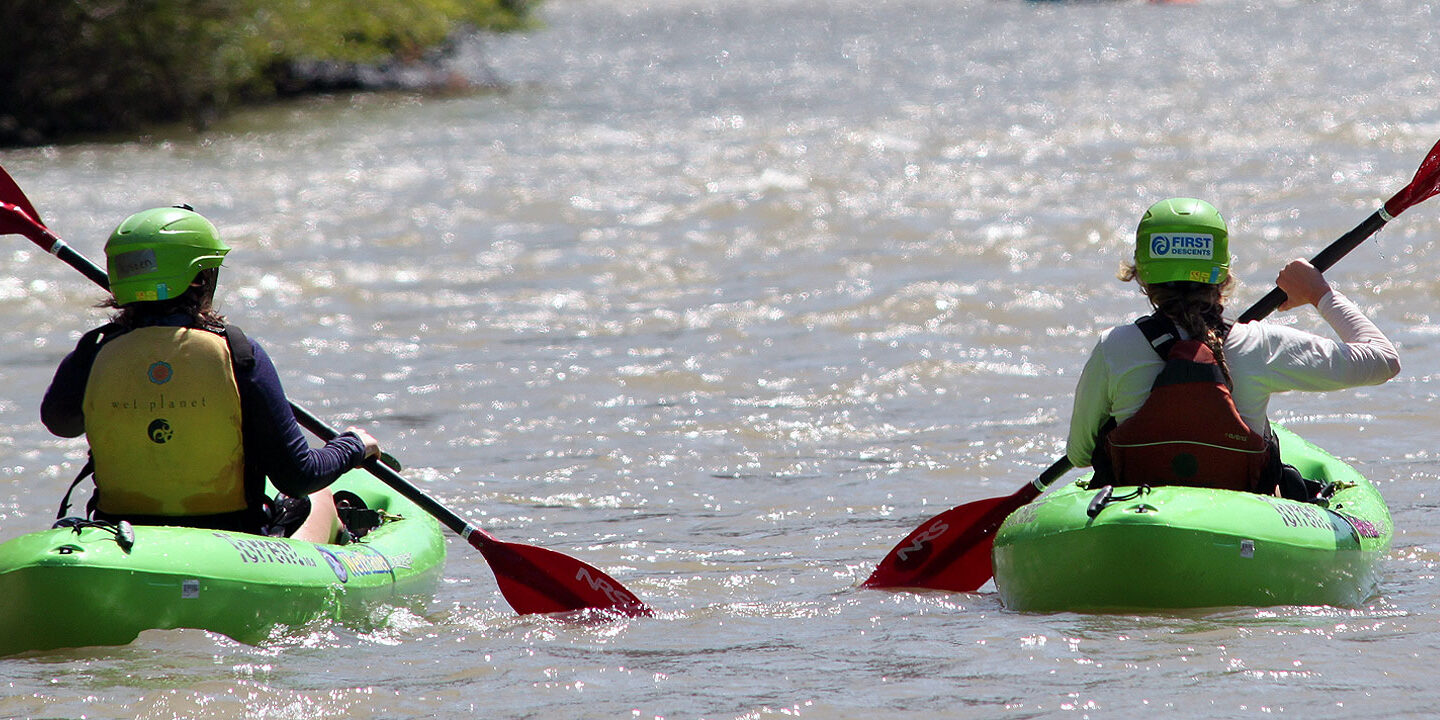 Two people paddling away on sit-on-top kayaks
