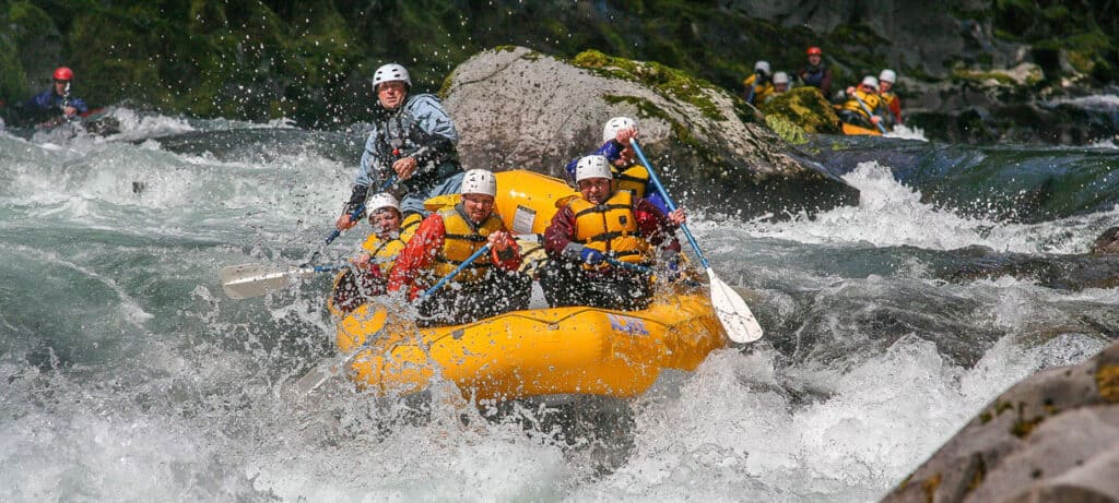 a group of rafters approaching a strong whitewater section sandwiched between rocks on the wind river