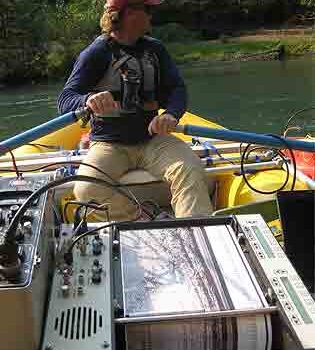 Person rowing down the White Salmon River with mapping equipment
