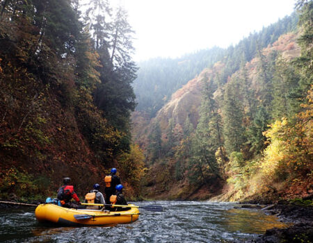 Group of people rowing on a river through a canyon