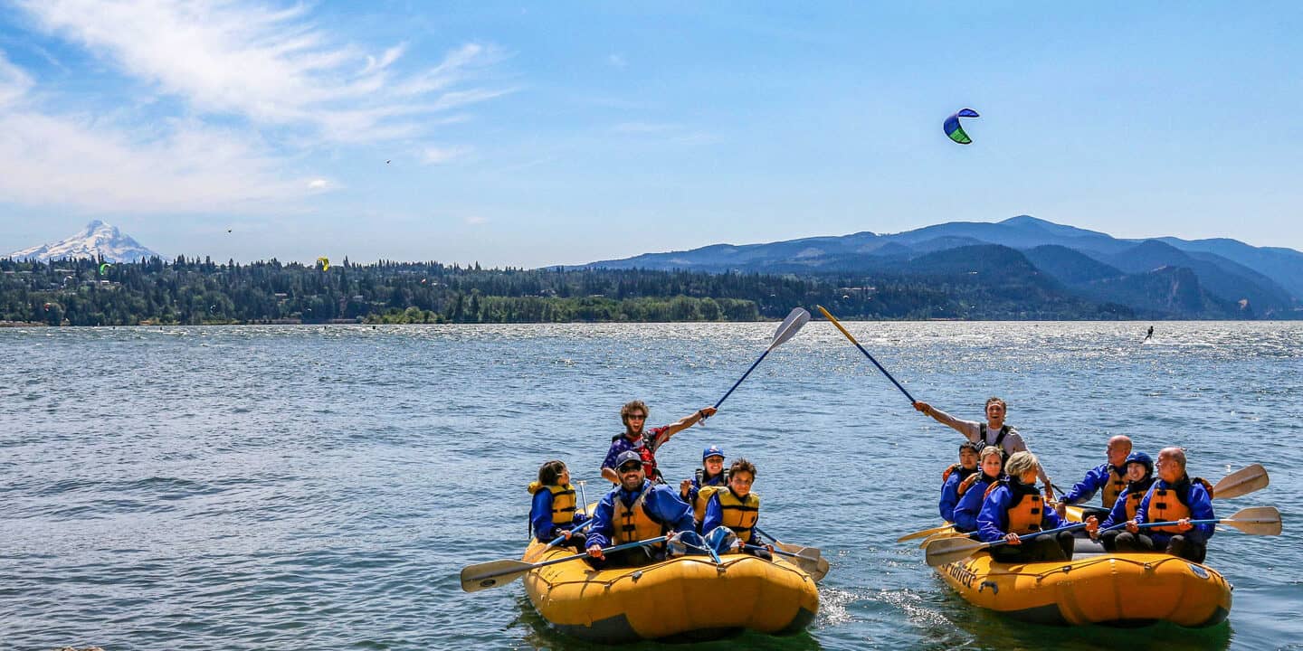Two groups of whitewater rafters do a paddle bump as they earn frequent floater points. Wet Planet Whitewater in Washington, Idaho, Oregon