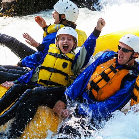 Young rafter celebrates while rafting through Rattlesnake Rapid on the White Salmon River in Washington