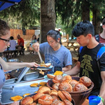 A wet planet staff member serves burgers during a river rafting and BBQ event at Wet Planet Whitewater - Oregon, Washington, and Idaho.