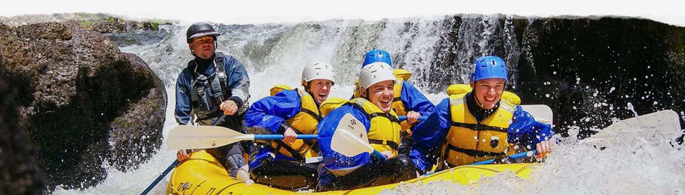 Group of rafters smile as they pass through some rough waters. Wet Planet Whitewater in Washington Oregon Idaho