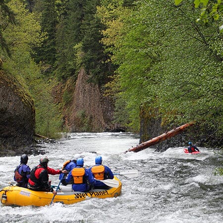 A group of rafters get ready to paddle through a narrow cliff walled gorge on a Hood River Oregon rafting trip.