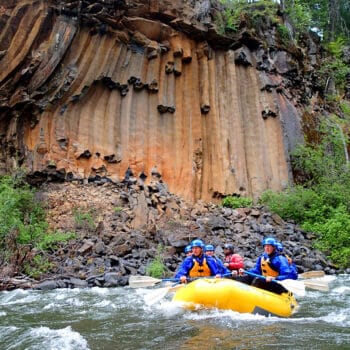 Copper colored basalt cliff walls provide classic Pacific Northwest scenery on Washington state's Klickitat River rafting trip.