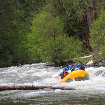 Rafters paddle through waves on a Klickitat River rafting trip.