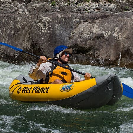 A paddler smiles while running a rapid in an inflatable kayak on the Main Salmon River in Idaho.