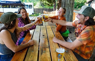 Friends enjoy a drink at the picnic table after their whitewater adventure at Wet Planet Whitewater in Washington, Idaho, Oregon