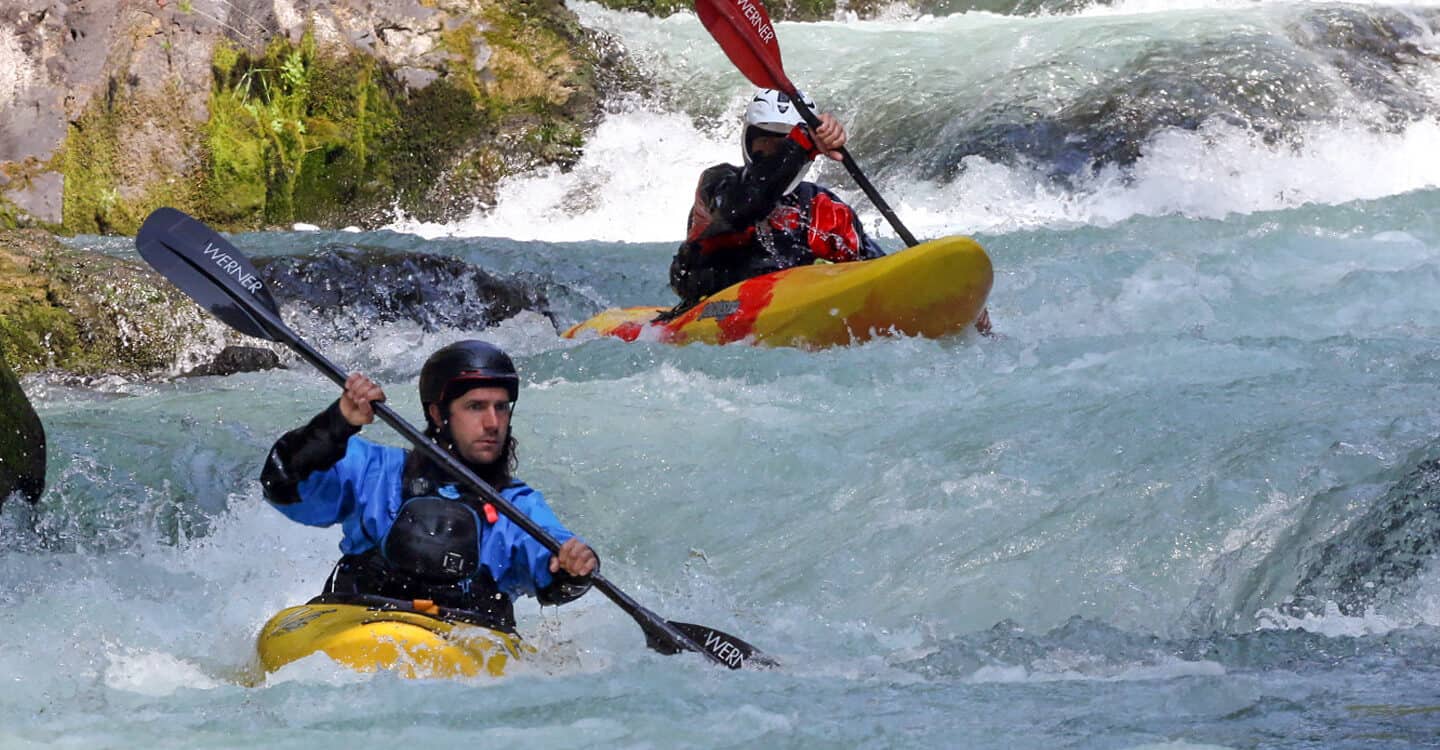 A kayaker follows his instructor through a rapid on a Washington river kayak instruction course.