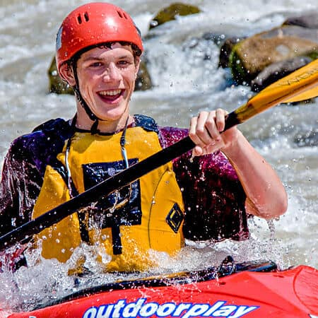 A beginner kayaking course student smiles while kayaking in Washington.