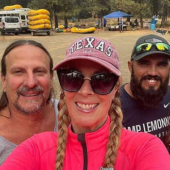 Three rafters pose for the camera with rafts in the background before a Tieton River rafting trip in Washington.