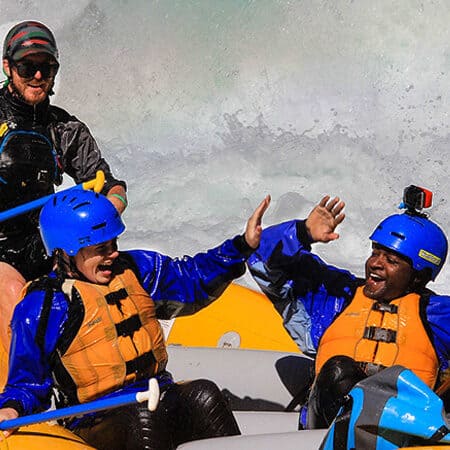 Two paddlers celebrate with high fives on a White Salmon River rafting trip - Oregon Washington