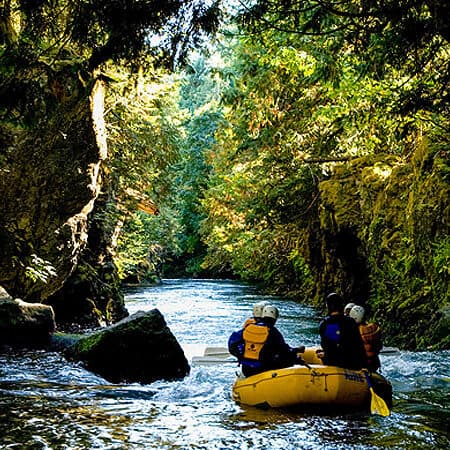 A scenic view from behind of a raft on a White Salmon River rafting trip in Washington and Oregon.