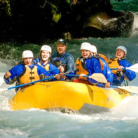 A group of excited rafters celebrate after running a rapid on a White Salmon River rafting trip - Oregon and Washington.