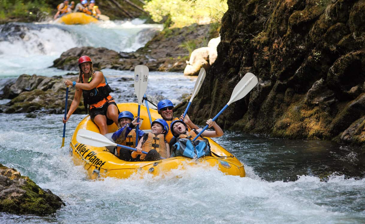 A family smiles and cheers while Rafting the White Salmon Rive through Top Drop Rapid