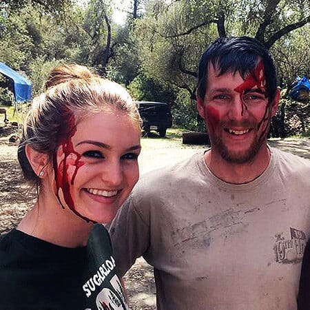 Two students on a Wilderness First Responder Course pose with makeup simulating blood on their faces.